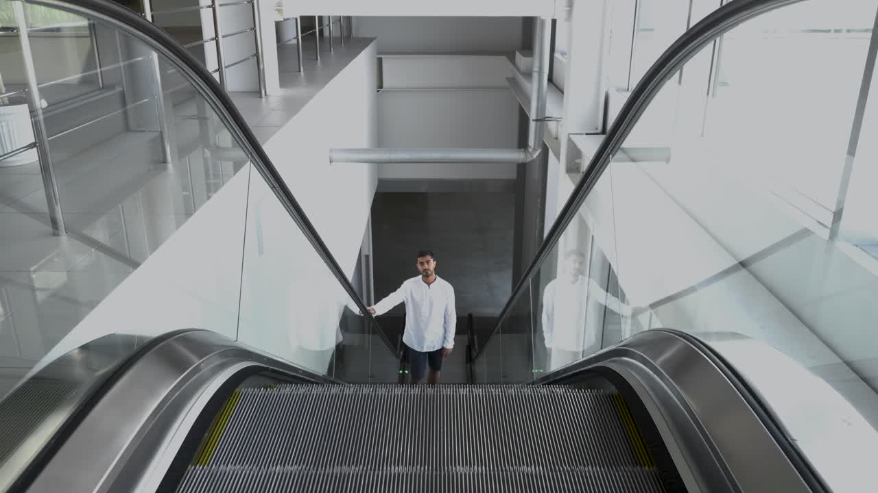 현대 건물 의 에스컬레이터 에 있는 사람