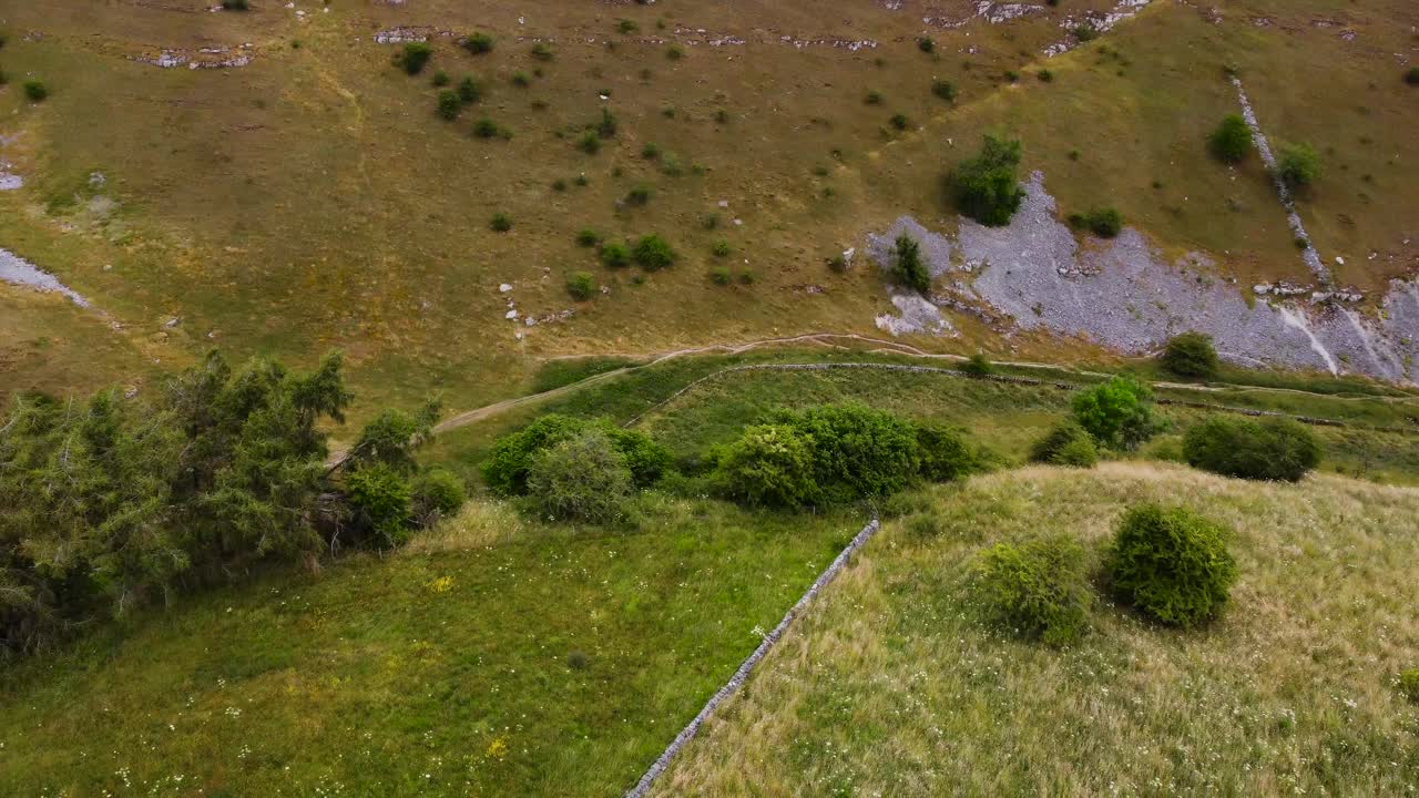 vista aérea por encima de la pared de piedra rústica en el idílico campo del valle de senderismo del distrito de los picos