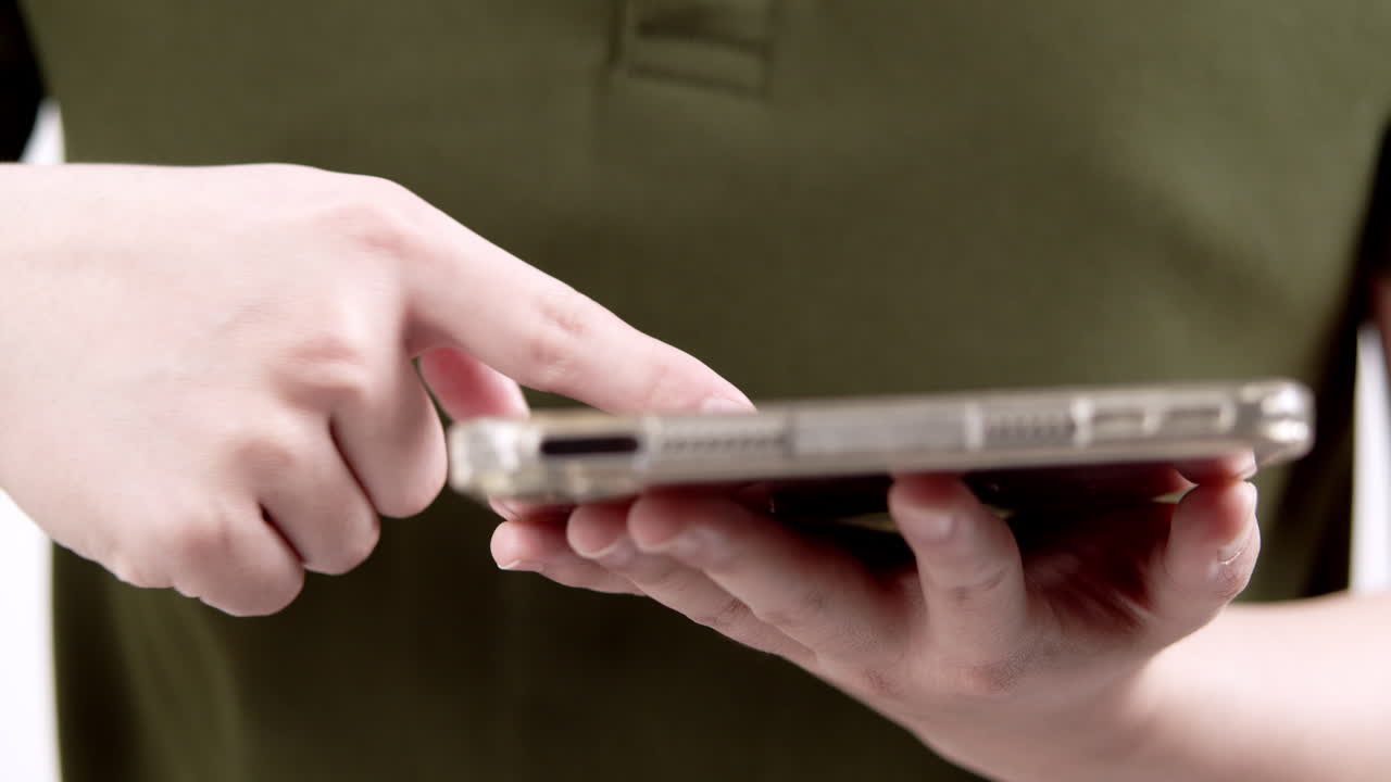 A young man is using his hands to scroll quickly through a tablet, highlighting the importance of technology in modern work environments.