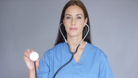 Attractive-doctor-holding-up-a-stethoscope