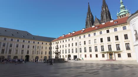 tourists gather in the second courtyard of prague castle under a clear blue sky on a sunny day