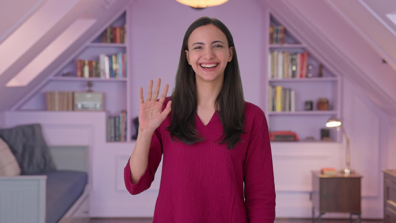 chica india feliz saludando a la cámara