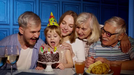 Adorable-child-girl-kid-eating-cake-making-wish,-having-fun,-celebrating-birthday-party-with-family