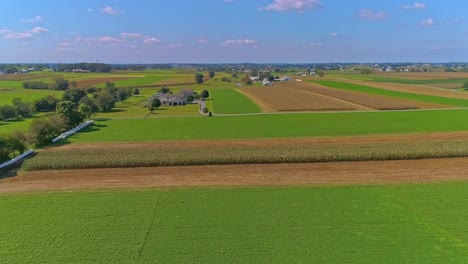 an aerial view of rural america of amish farmlands with fields needing harvesting on a sunny summer day