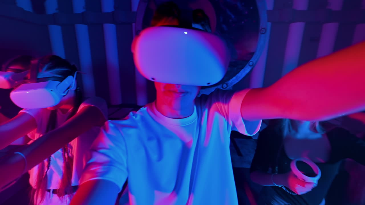 A team of young friends play virtual reality games in VR equipment on an arena. Neon lights