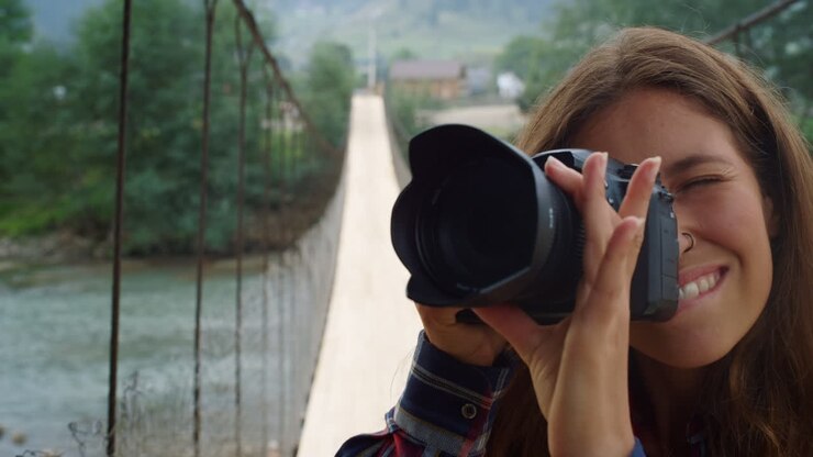 Fotografo che riprende un paesaggio montano naturale. Una donna scatta foto con la macchina fotografica.
