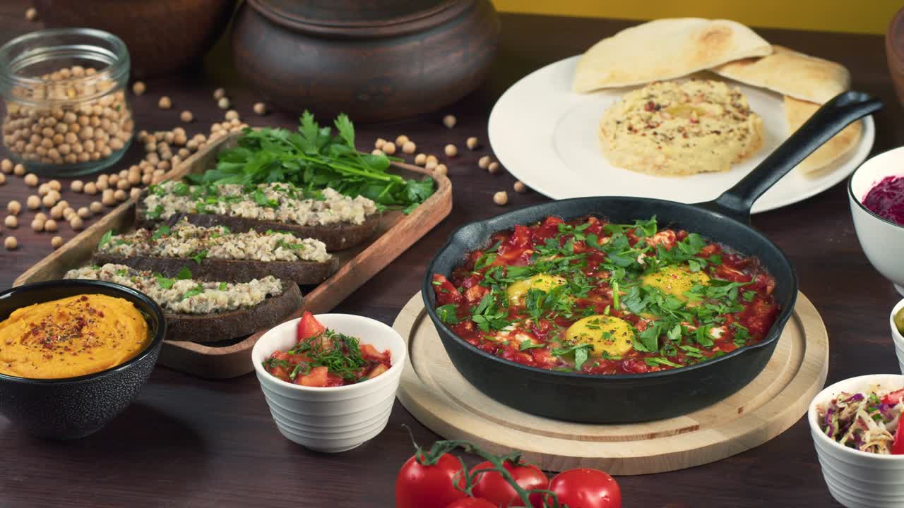 이스라엘 요리: 손으로 샤크슈카를 넣고, 파슬리로 장식합니다. 토마토 소스, 뜨거운 고추, 양파 및 향신료, 중동 문화, 포쉬마크 및 후무스로 만든 국가 유대 요리.