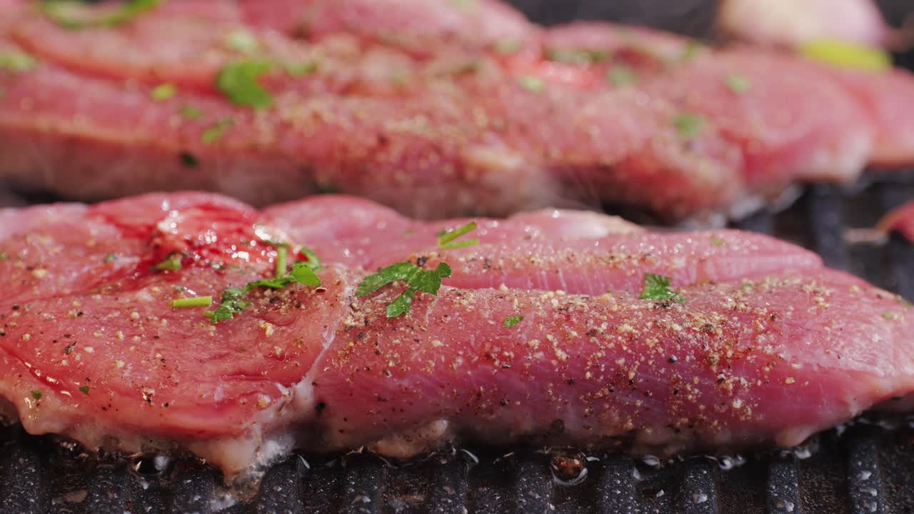 Cooking raw turkey meat in spices with garlic and greens on grill close-up. Fry chicken or turkey slice on frying pan Grilled chicken, duck, turkey kebab with vegetables.