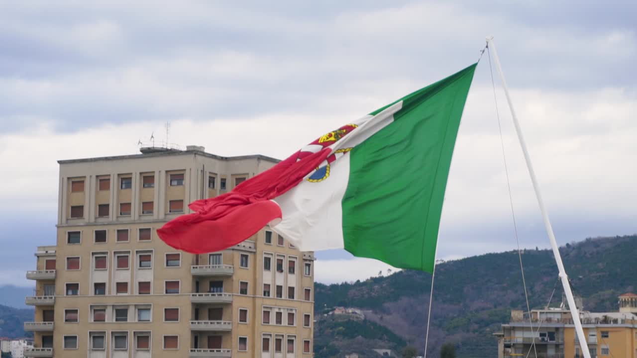 итальянский флаг неаполя, развевающийся над городскими зданиями.