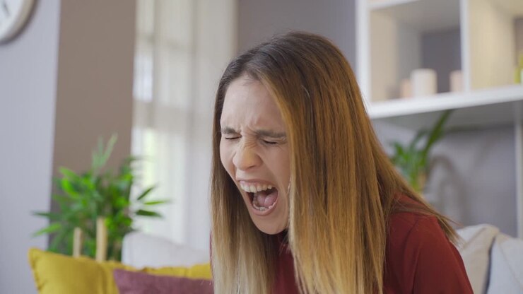 Screaming young woman in slow motion. Shouting, being abused, getting upset, having a nervous breakdown.