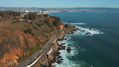 Vista-Aérea-Siguiendo-La-Avenida-Borgoño-Frente-Al-Mar-Carretera-Costera-Junto-A-Las-Olas-Del-Océano-Afluente-De-Reñaca