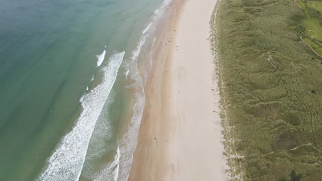 Sea-Waves-Running-To-The-White-Sand-Shore-Of-Whiterocks-Beach-In-Portrush,-Northern-Ireland-On-A-Summer-Day---aerial