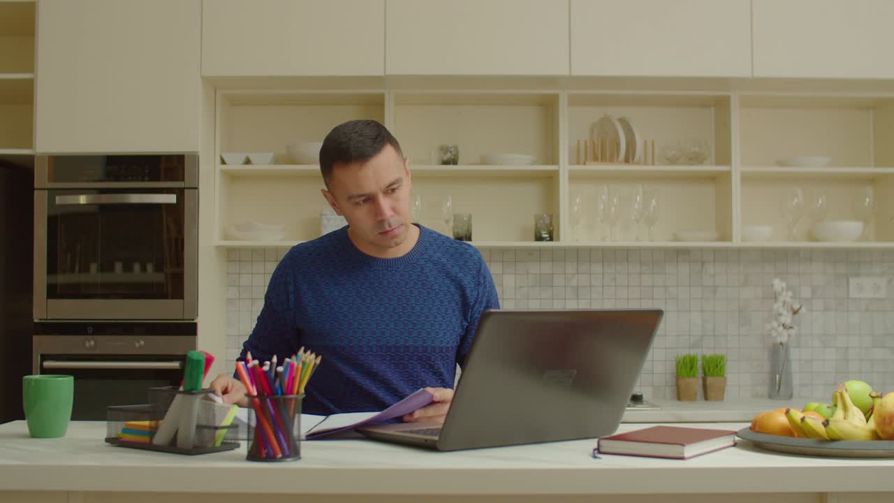 Focused man with laptop pc working on freelance project from home