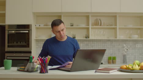 hombre enfocado con una computadora portátil trabajando en un proyecto independiente desde casa
