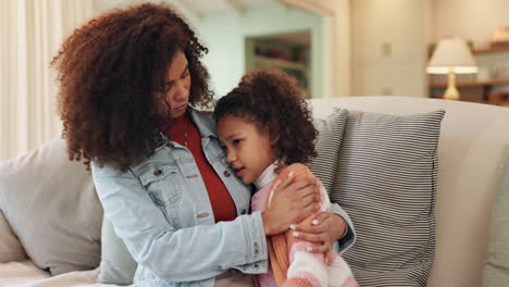 mother and daughter embracing on couch