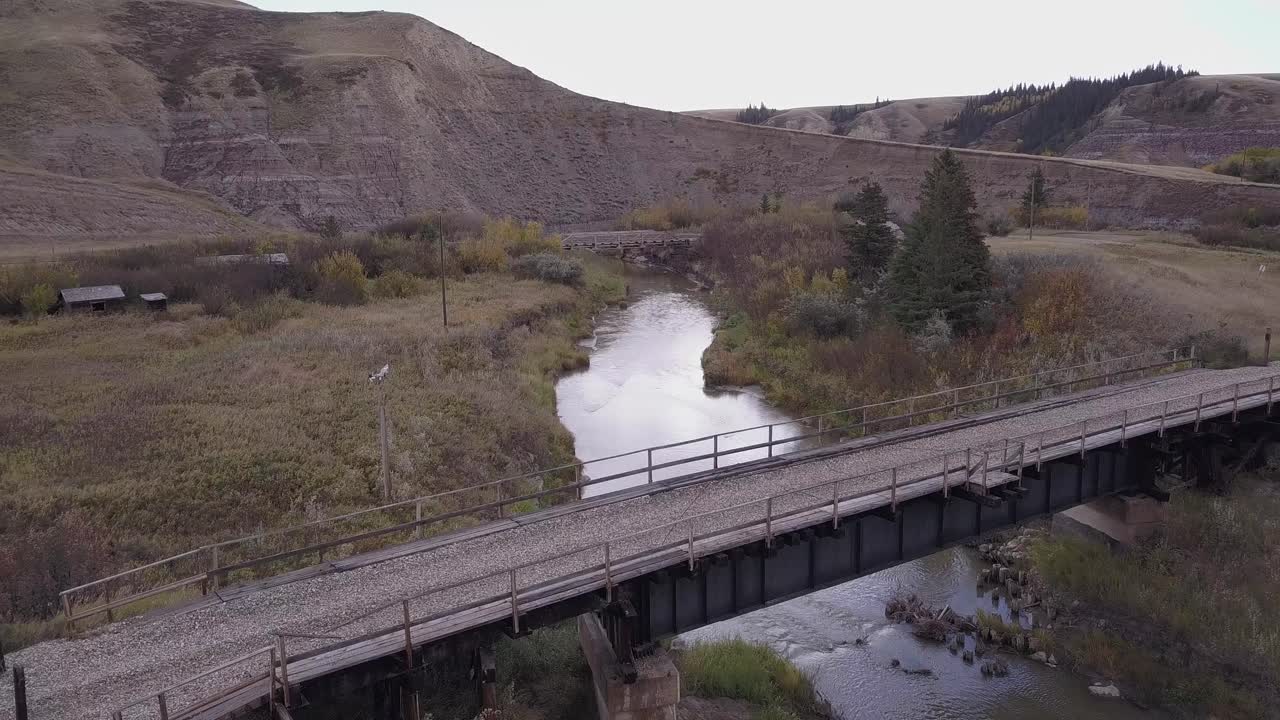 황무지의 로즈버드 강을 가로지르는 오래된 다리와 침식 절벽 너머