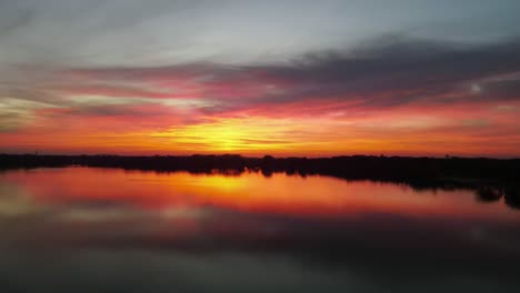 toma aérea de una vibrante puesta de sol sobre un lago