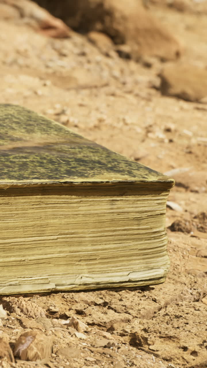 Un libro antico posato sulla sabbia desertica illuminata dal sole rivela i segreti del tempo