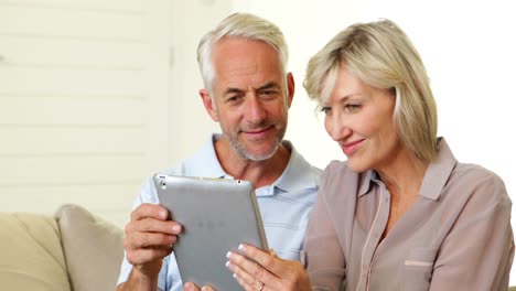pareja usando su tableta juntos en el sofá