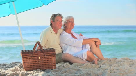 pareja madura abrazándose en una playa