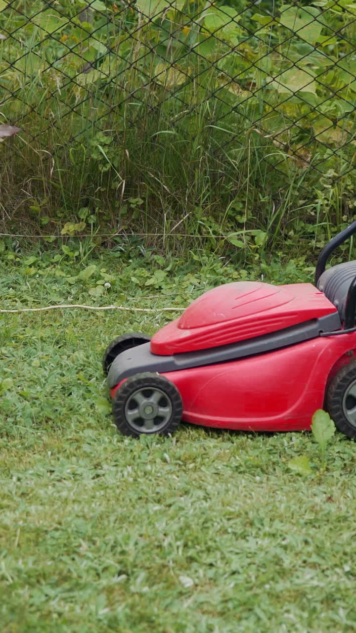 Close-up of mowing the lawn. Outdoor seasonal household works Vertical video