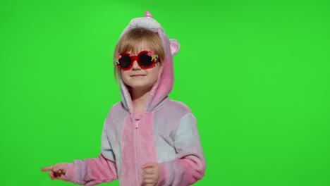 Little-blonde-child-girl-smiling,-dancing,-celebrating-in-unicorn-pajamas-costume-on-chroma-key