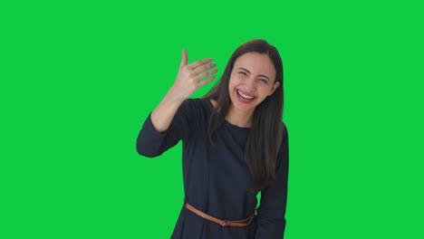 chica india feliz señalando y llamando a alguien pantalla verde