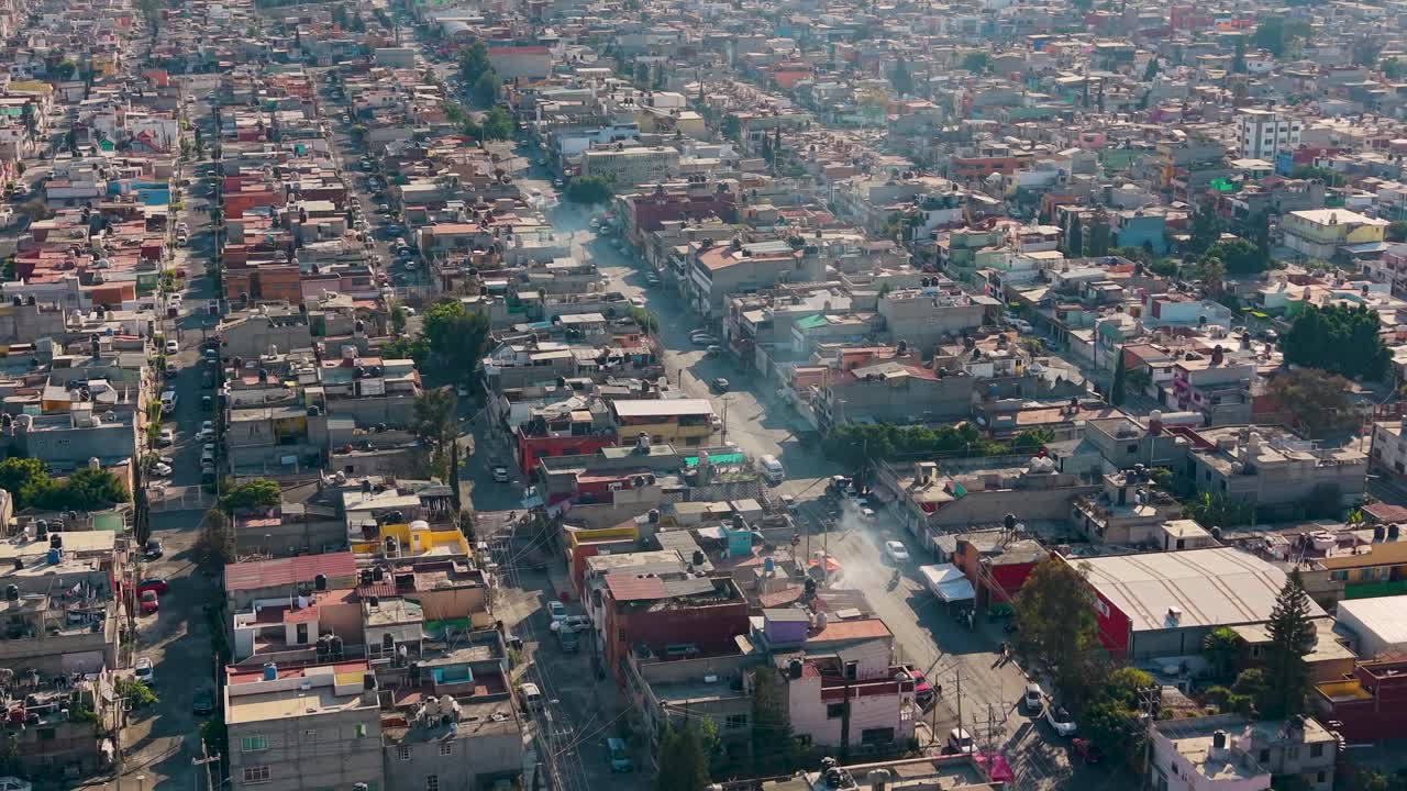 Ripresa drone bassa della griglia stradale di Ecatepec con case dense e attività urbana.