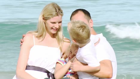 close up of happy family sitting on the beach