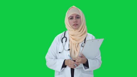 serious muslim doctor talking to patient green screen