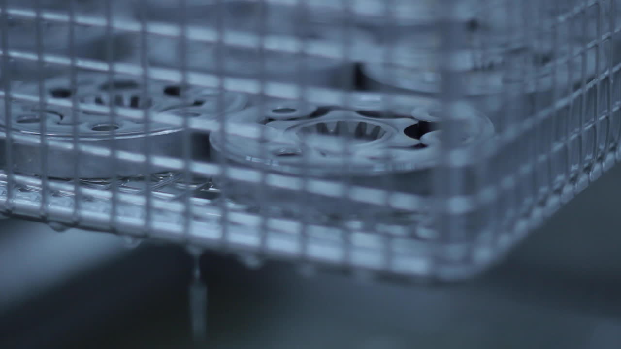 контейнер с металлическими билетами, поднимающимися из резервуара с химической жидкостью