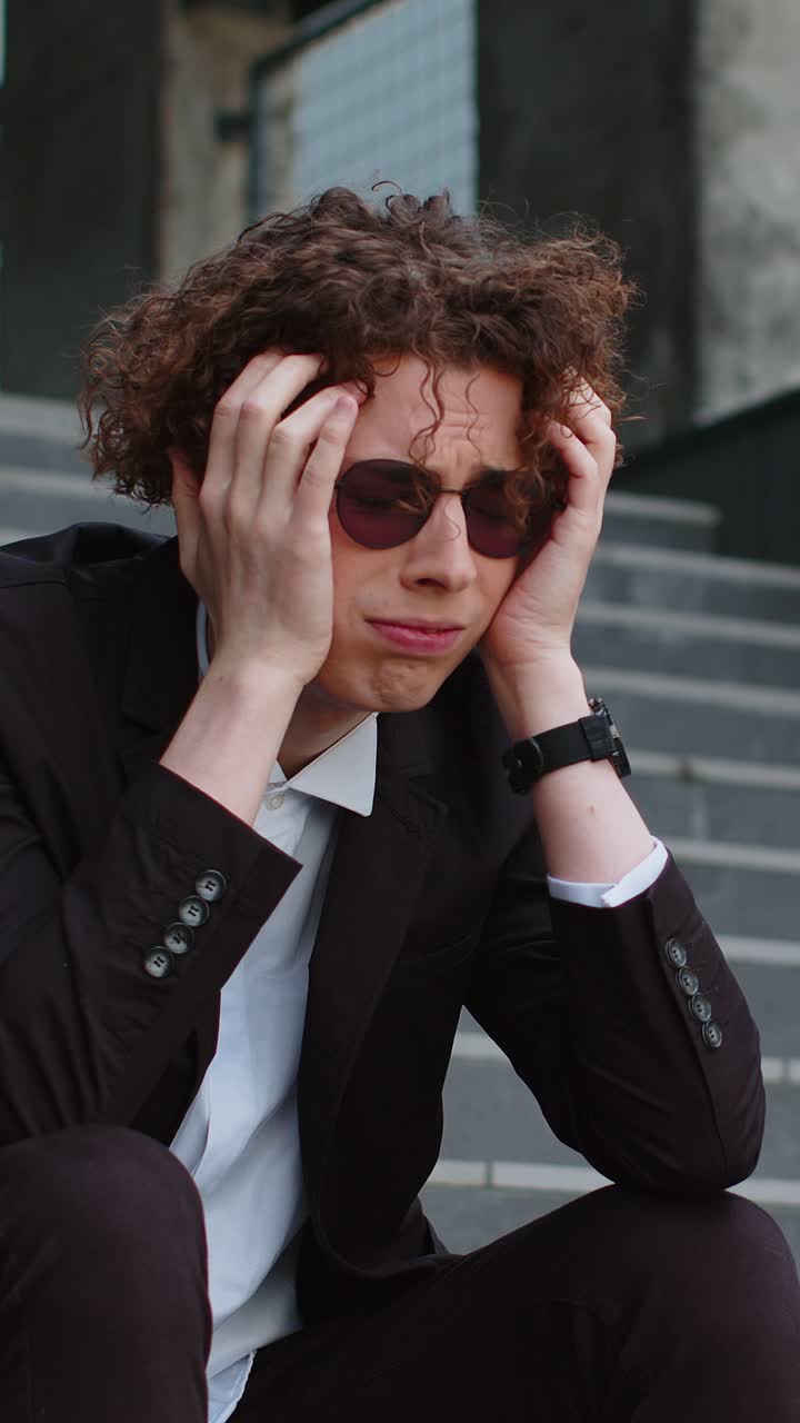 Sad caucasian businessman sitting outside on the steps of an office building bankrupt lost his job