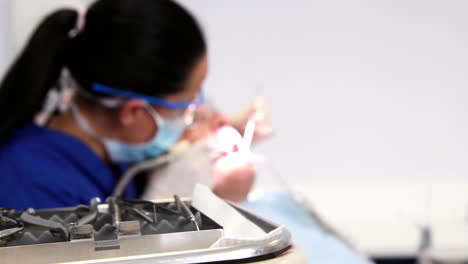 dentist examining a patients teeth in the dentists chair