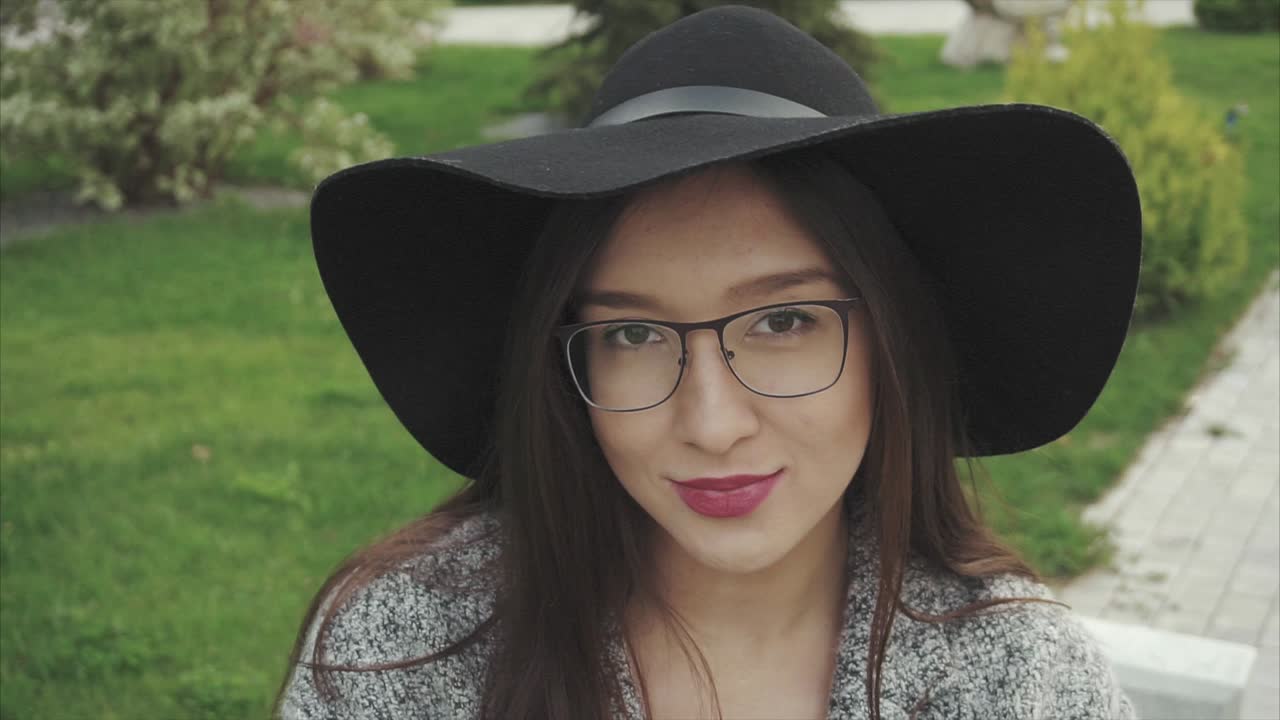 mujer con sombrero y gafas en un parque