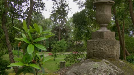 Toma-Estática-De-Algunas-Hojas-En-El-Viento-Junto-A-Una-Escultura-De-Piedra-En-Un-Parque.