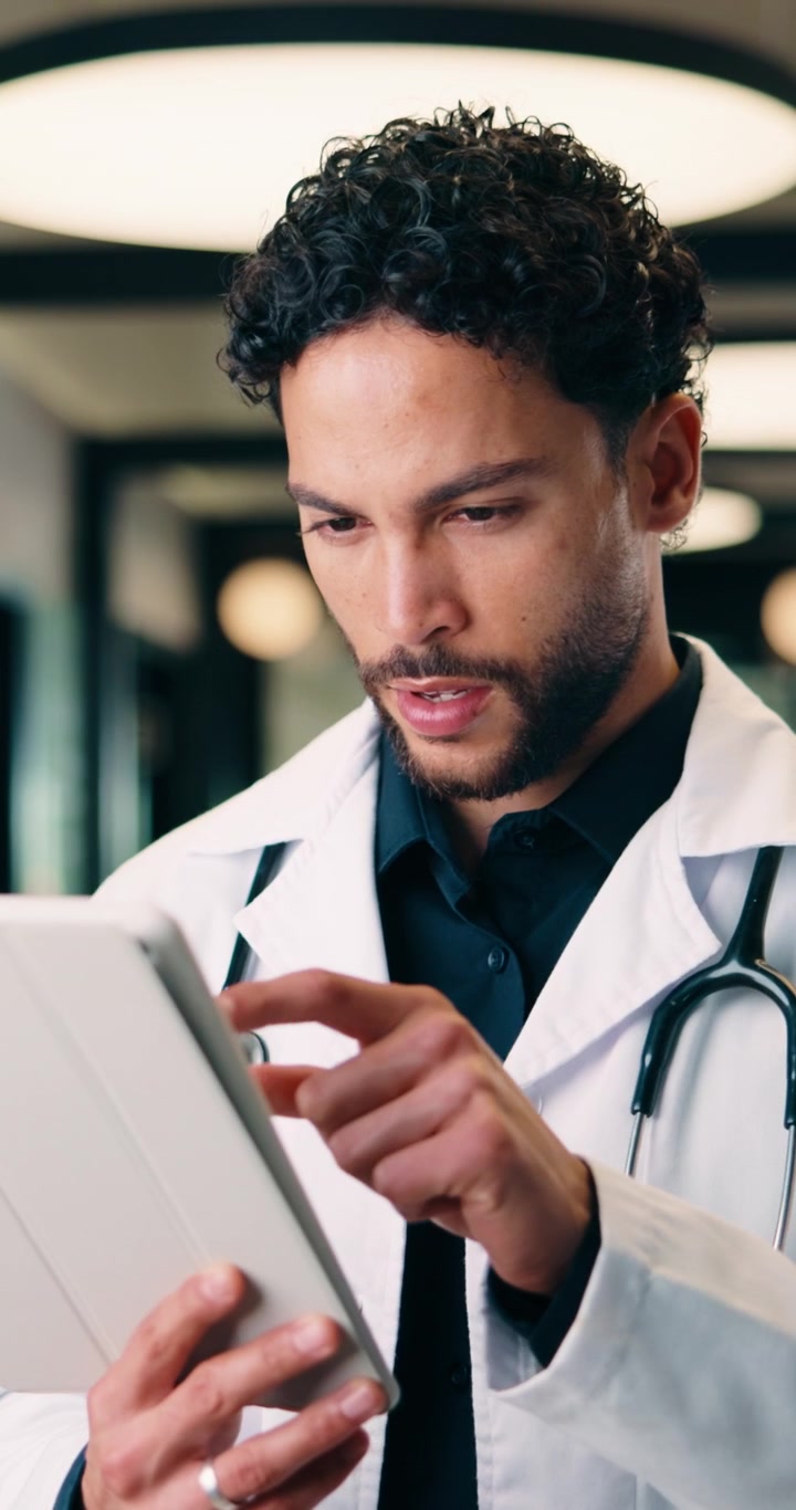 Medico uomo che utilizza un tablet digitale nel corridoio dell'ospedale
