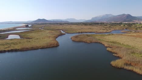 aerial - a river flowing in a plain in sardinia