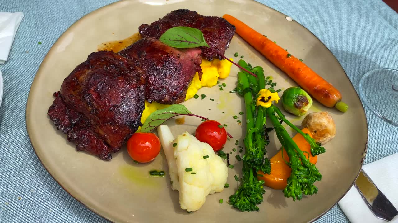 tiernas mejillas de cerdo cocidas a fuego lento y verduras en un plato, comida sabrosa en un restaurante, tiro de 4k