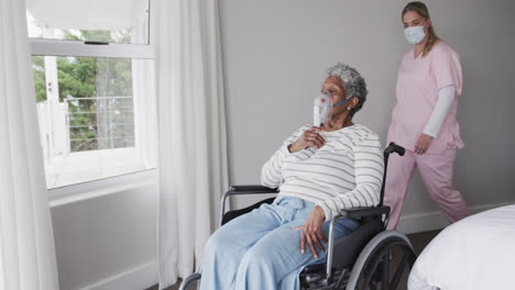 enfermera caucásica con máscara facial, anciana afroamericana con máscara de oxígeno, cámara lenta