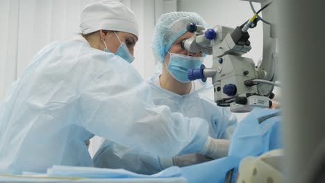 equipo de cirugía haciendo cirugía de estrabismo utilizando tecnologías modernas, dispositivos más recientes, microscopio en una clínica moderna