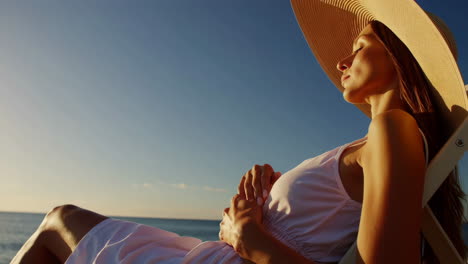 mujer relajándose en una silla de playa al atardecer