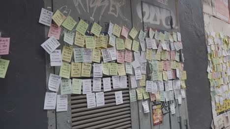 static shot of messages in chinese on colourful post it notes on street wall