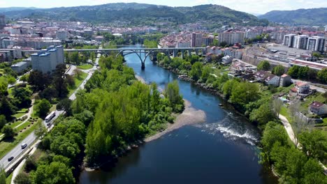 Miño-river-flows-through-downtown-of-Ourense-during-day,-Spain,-aerial