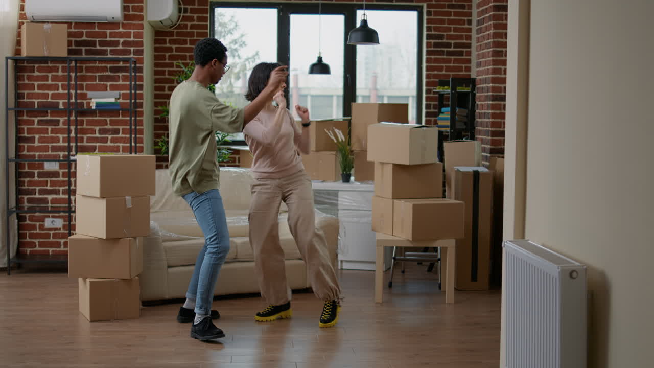 Mand og kone danser og fjoller rundt i nyt hjem