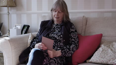 woman reading on tablet on couch