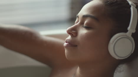 woman relaxing in a bath with headphones