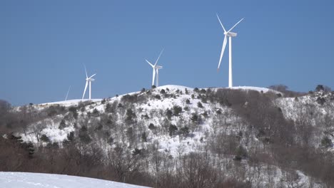 wind turbines are operating to generate electricity in the snow-covered mountain, portugal