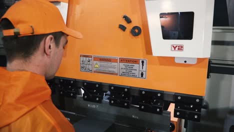 trabajador inspeccionando el freno de la prensa de metal