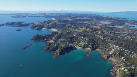 aerial view over beaches in waiheke island, auckland, new zealand - drone shot