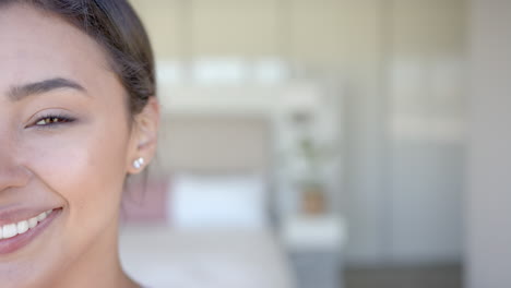 smiling woman with earrings, close-up of face, relaxing at home, copy space